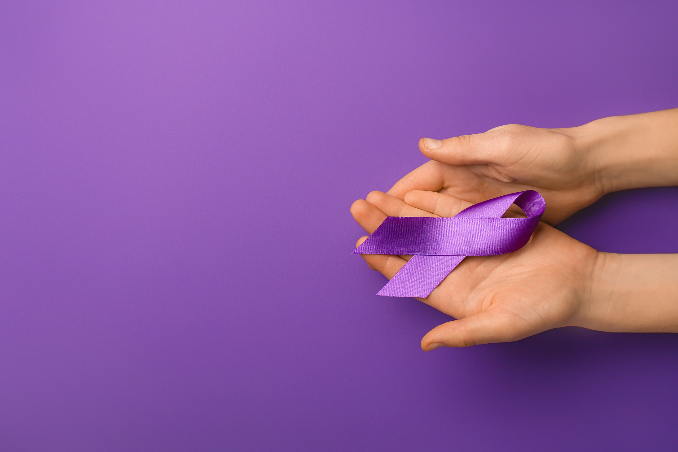 Female Hands with Violet Ribbon on Purple Background